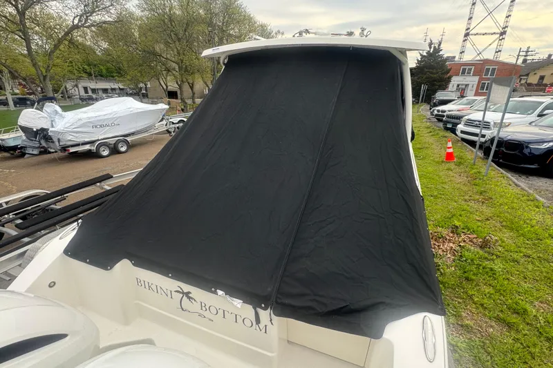 Slide: The Image of 2022 Pursuit DC 266 Dual Console boat with black cover, parked outdoors. - 23