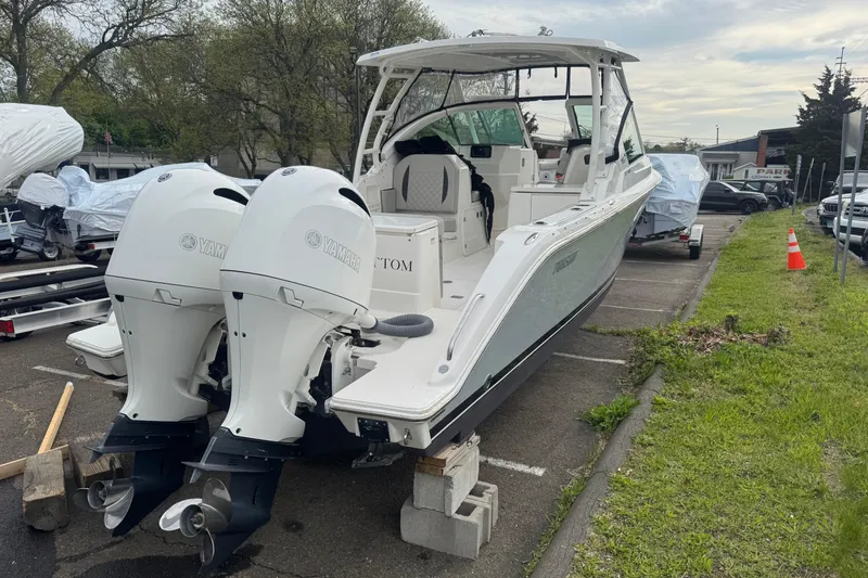 Slide: The Image of 2022 Pursuit DC 266 Dual Console boat with twin Yamaha engines in a parking lot. - 3