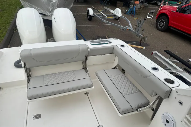 Slide: The Image of 2022 Pursuit DC 266 Dual Console boat with gray seating and twin engines. - 4