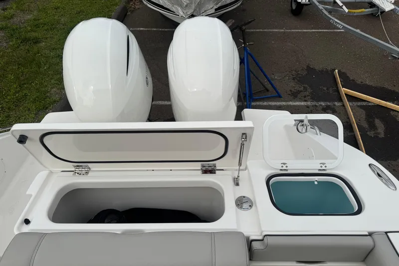 Slide: The Image of 2022 Pursuit DC 266 Dual Console boat with open storage compartments and twin engines. - 6