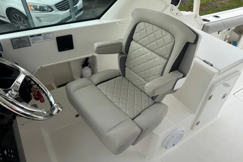 Slide: The Image of Captain's seat on 2022 Pursuit DC 266 Dual Console boat, featuring quilted upholstery. - 9