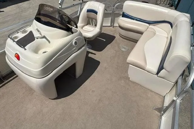 Slide: The Image of 2008 Sun Tracker Party Barge 18 DLX interior with helm, seating, and carpeted deck. - 12