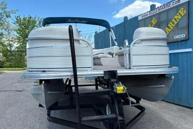 Slide: The Image of 2008 Sun Tracker Party Barge 18 DLX pontoon boat on trailer, parked outdoors. - 2