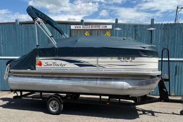 Slide: The Image of 2008 Sun Tracker Party Barge 18 DLX pontoon boat on trailer, covered and parked. - 21