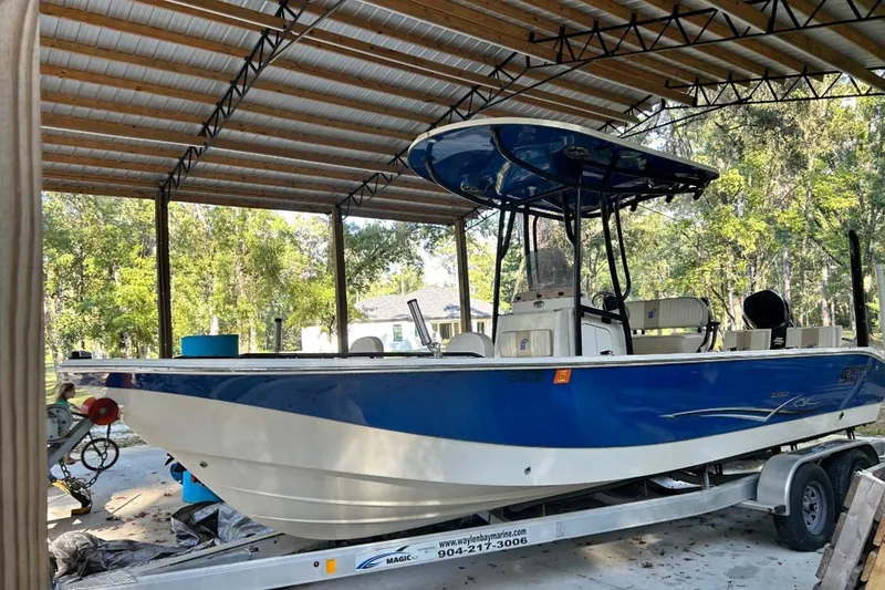 The Image of 2017 Carolina Skiff 24 Ultra Elite boat on trailer under metal canopy. - 1