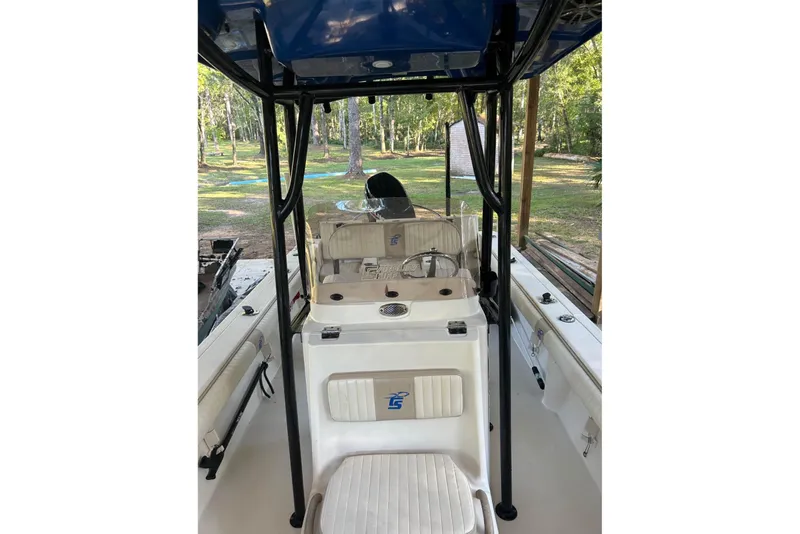Slide: The Image of 2017 Carolina Skiff 24 Ultra Elite boat interior with console and seating, surrounded by trees. - 5
