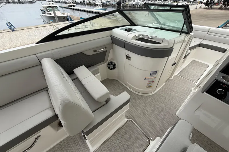 Slide: The Image of 2024 Sea Ray SDX 270 Outboard interior with sleek seating and modern design at a marina. - 9
