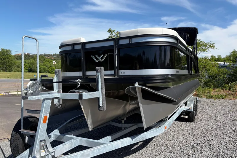 Slide: The Image of 2026 Whisper D21 XRE CRUISE pontoon boat on trailer, parked outdoors. - 3
