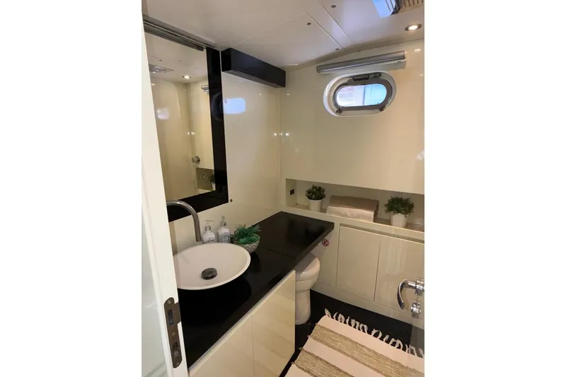 Slide: The Image of Luxurious yacht bathroom with modern fixtures, black countertop, and porthole window, CNM Continental 2015. - 11