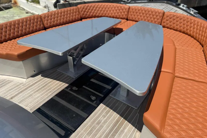 Slide: The Image of Luxurious seating area on a 2015 CNM Continental yacht with sleek tables and quilted cushions. - 14