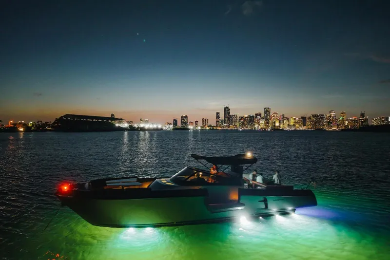 Slide: The Image of Luxurious CNM Continental yacht illuminated at night with city skyline backdrop, 2015 model. - 23