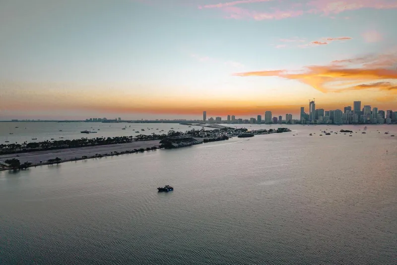 Slide: The Image of Aerial view of a coastal city skyline at sunset with calm waters. - 26