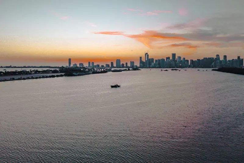Slide: The Image of Sunset over city skyline and water, featuring a 2015 CNM Continental boat. - 37