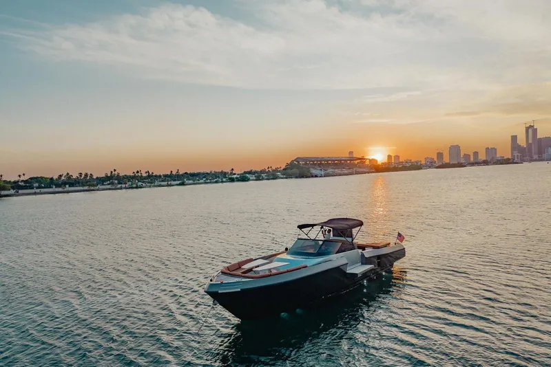 Slide: The Image of Luxury CNM Continental boat on water at sunset, city skyline in background, 2015 model. - 43