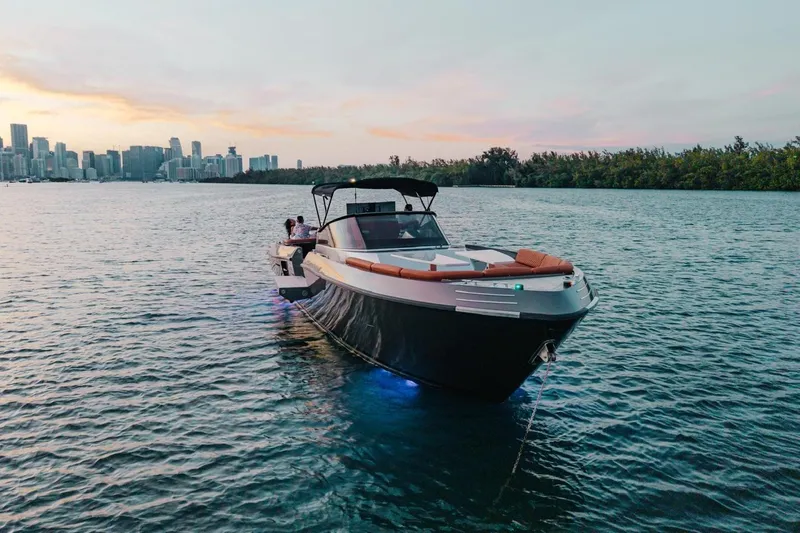 Slide: The Image of Luxury CNM Continental 2015 yacht on water at sunset with city skyline backdrop. - 52