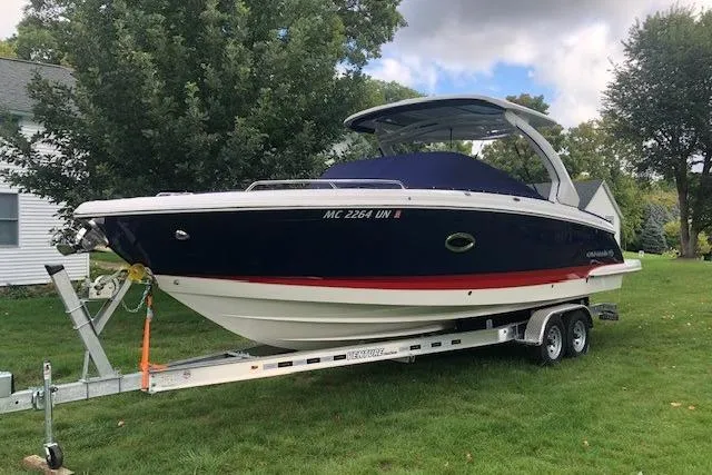 The Image of 2021 Chaparral 307 SSX boat on trailer, parked on grass with trees in background. - 0