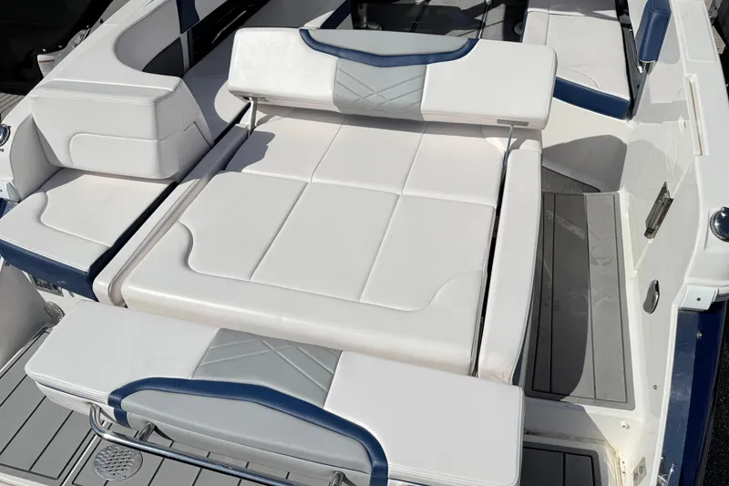 Slide: The Image of 2021 Chaparral 307 SSX boat interior with white and blue cushioned seating. - 7
