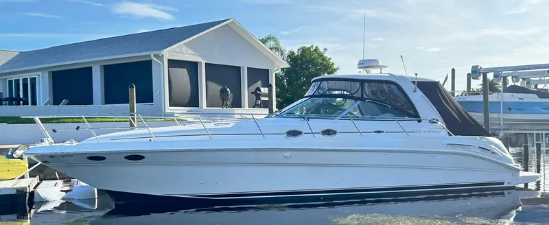 Slide: The Image of 2003 Sea Ray 410 Express Cruiser docked by a house. - 12