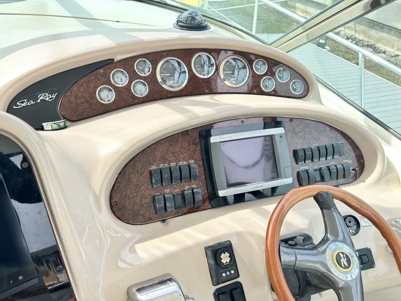 Slide: The Image of Dashboard of a 2003 Sea Ray 410 Express Cruiser with wood paneling. - 13