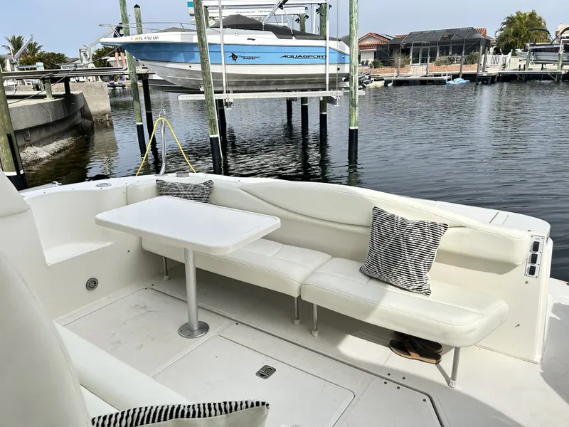 Slide: The Image of 2003 Sea Ray 410 Express Cruiser with seating area and table by the water. - 19