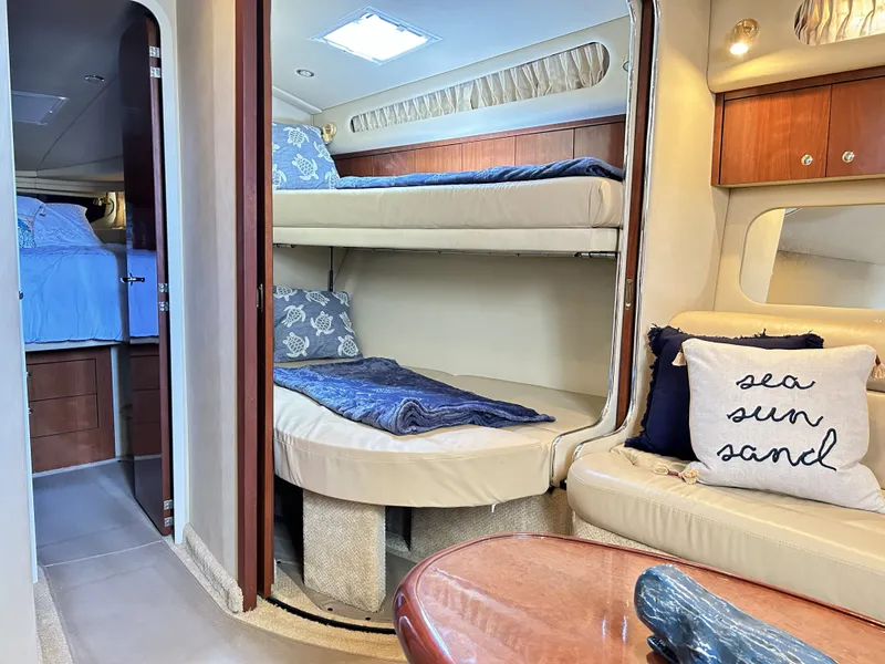 Slide: The Image of Interior of 2003 Sea Ray 410 Express Cruiser with bunk beds and pillows. - 35