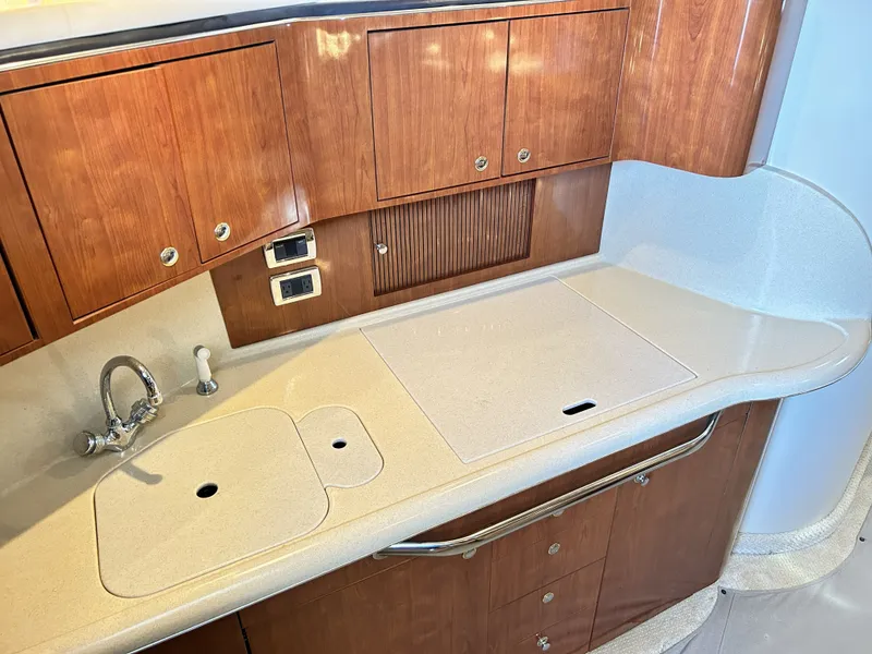 Slide: The Image of Sea Ray 410 Express Cruiser 2003 kitchen area with wooden cabinets. - 41