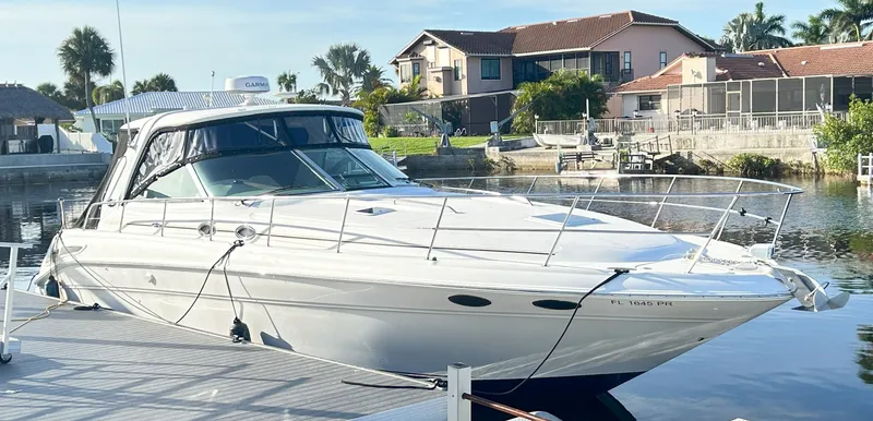Slide: The Image of 2003 Sea Ray 410 Express Cruiser docked by waterfront homes. - 5