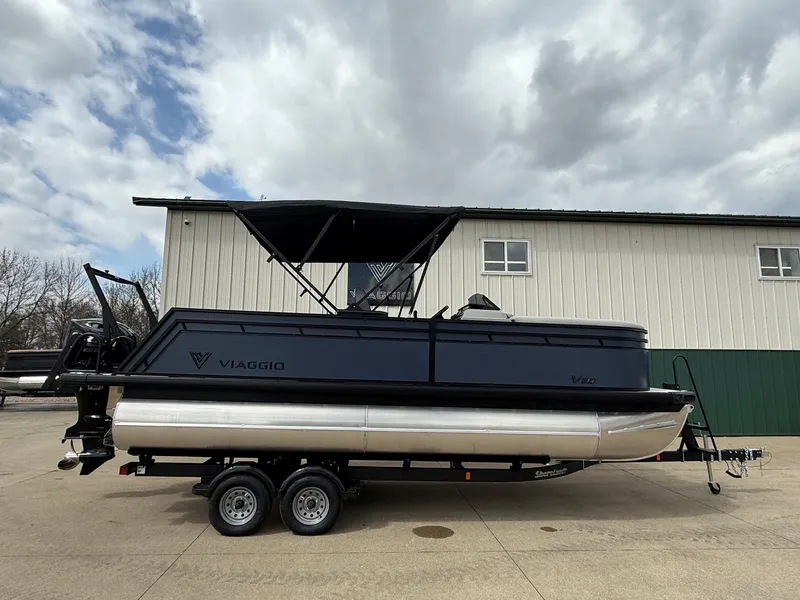 The Image of Viaggio Lago V 20C 2026 pontoon boat on trailer in front of building. - 0