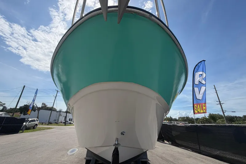 Slide: The Image of 2004 Bayliner 2452 Ciera Express boat on display, turquoise hull, RV sale banner visible. - 11