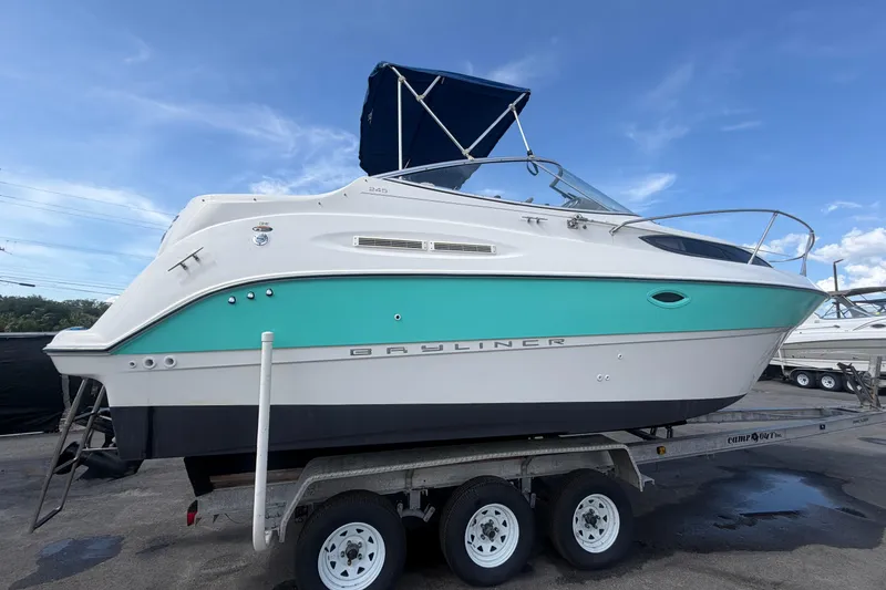 Slide: The Image of 2004 Bayliner 2452 Ciera Express boat on trailer under blue sky. - 2