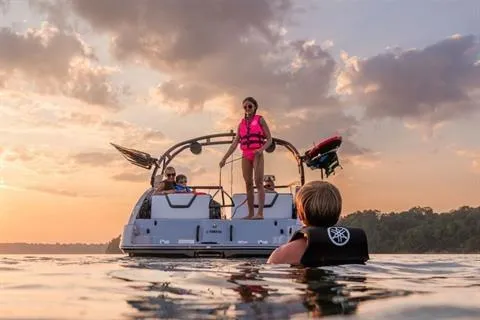 Slide: The Image of 2026 Yamaha 252XE boat on water at sunset with people enjoying water activities. - 10