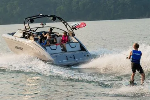 Slide: The Image of 2026 Yamaha 252XE boat towing a wakeboarder on a lake. - 11