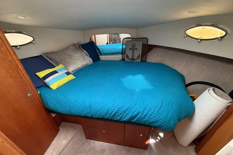 Slide: The Image of Cozy cabin interior of 1998 Silverton 372 Motor Yacht with blue bedding and decorative pillows. - 10