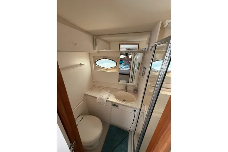 Slide: The Image of 1998 Silverton 372 Motor Yacht bathroom with sink, toilet, and shower. - 11