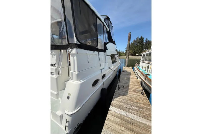Slide: The Image of 1998 Silverton 372 Motor Yacht docked, featuring sleek design and spacious deck area. - 2