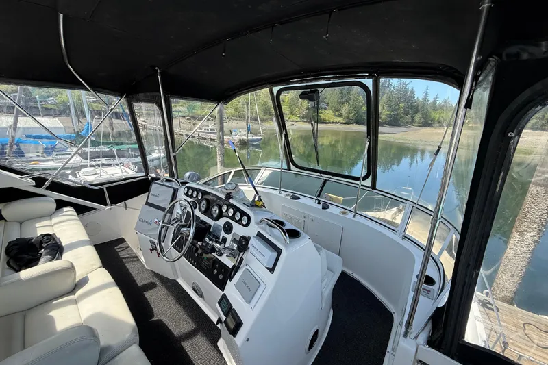 Slide: The Image of 1998 Silverton 372 Motor Yacht helm with panoramic marina view. - 3