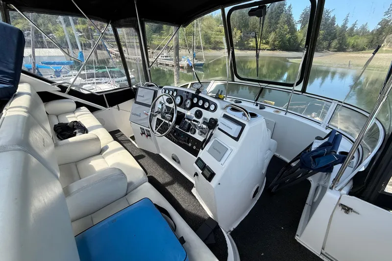 Slide: The Image of Interior view of 1998 Silverton 372 Motor Yacht cockpit with steering wheel and seating. - 4
