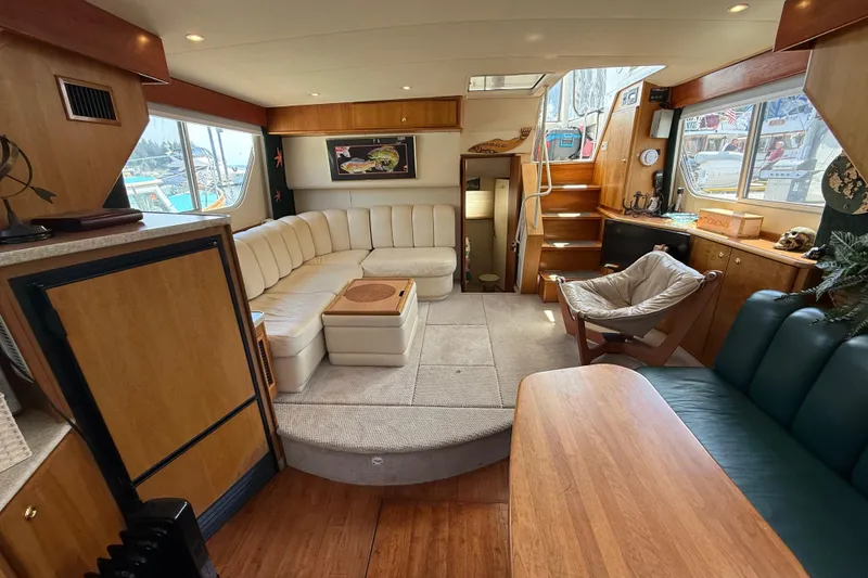 Slide: The Image of Interior of a 1998 Silverton 372 Motor Yacht with cozy seating and wooden accents. - 5