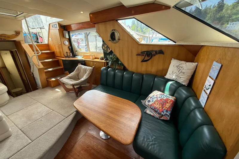 Slide: The Image of Interior of a 1998 Silverton 372 Motor Yacht with cozy seating and wooden accents. - 7