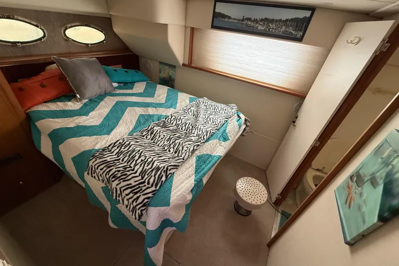 Slide: The Image of Cozy bedroom in 1998 Silverton 372 Motor Yacht with chevron bedding and nautical decor. - 8