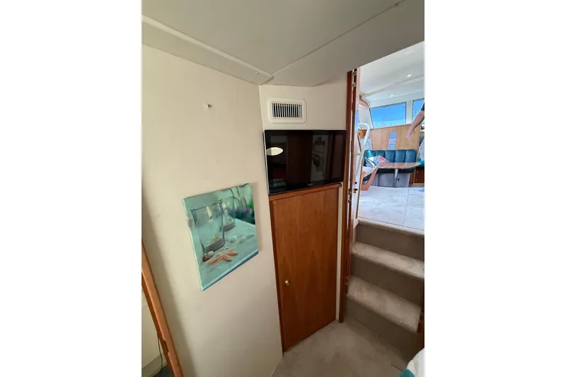 Slide: The Image of Interior of 1998 Silverton 372 Motor Yacht with stairs, TV, and wall art. - 9