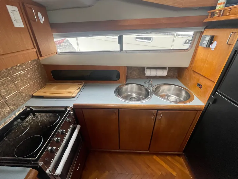 Slide: The Image of 1992 Bayliner 38 Motoryacht kitchen with stove and double sink. - 24