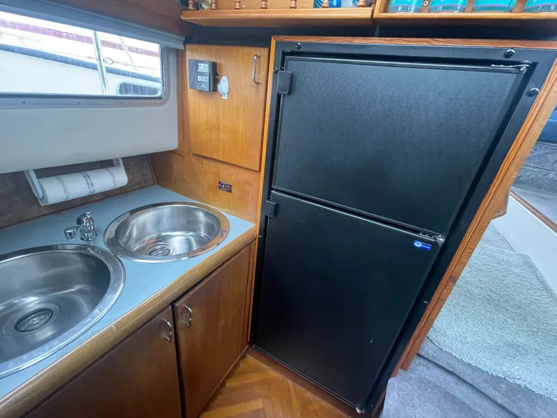 Slide: The Image of 1992 Bayliner 38 Motoryacht kitchen area with sink and refrigerator. - 25