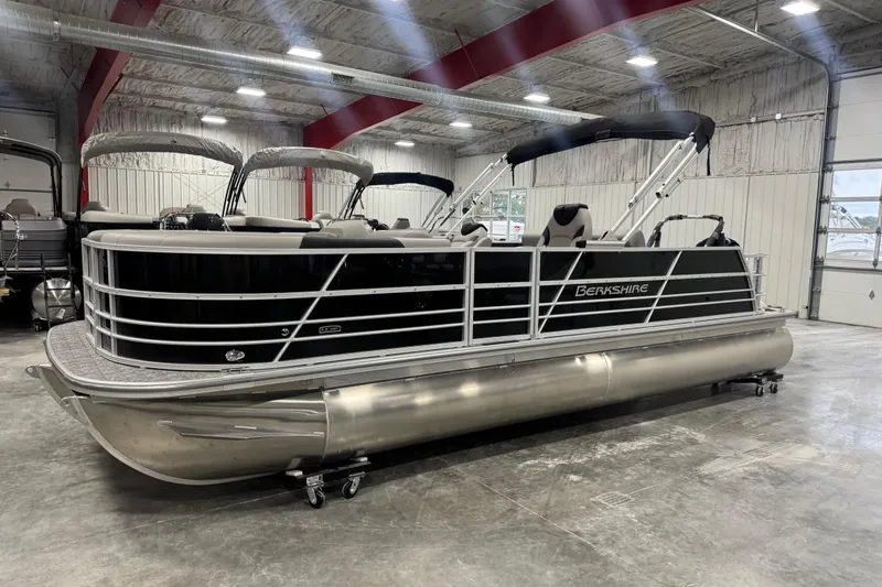 The Image of 2026 Berkshire 24 UL LE pontoon boat in a spacious indoor showroom. - 1