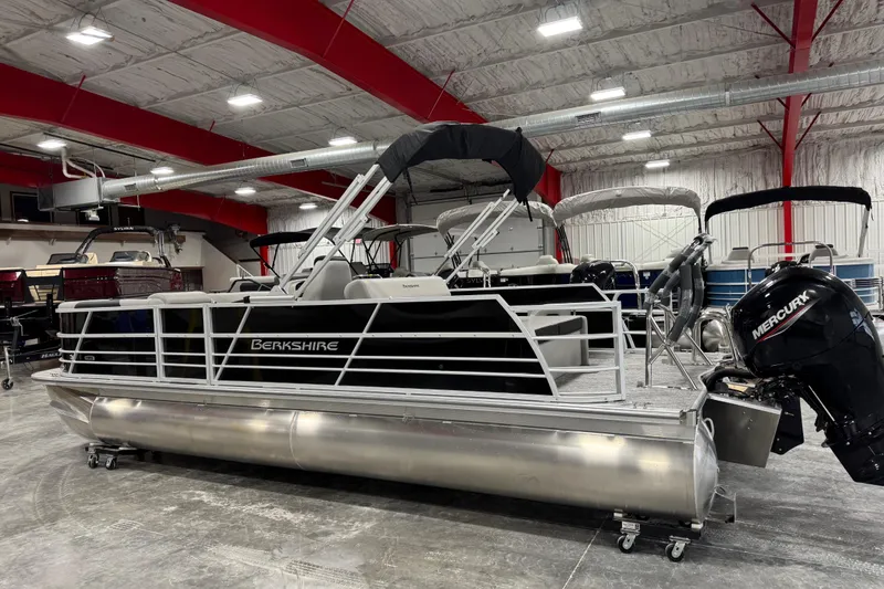 Slide: The Image of 2026 Berkshire 24 UL LE pontoon boat in showroom with Mercury outboard motor. - 3