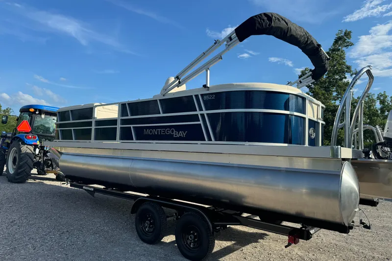 Slide: The Image of 2026 Montego Bay 8522 BR DLX pontoon boat on trailer, parked outdoors. - 6