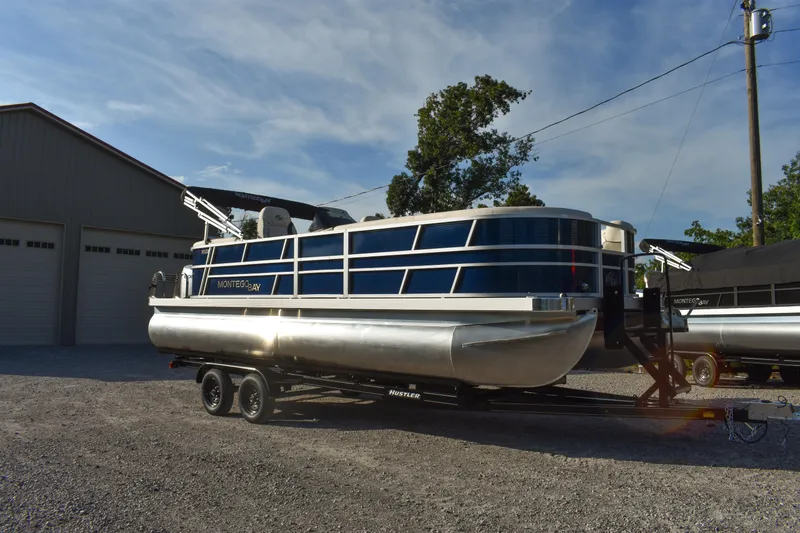 Slide: The Image of 2026 Montego Bay 8522 BR DLX pontoon boat on trailer, parked outdoors. - 7