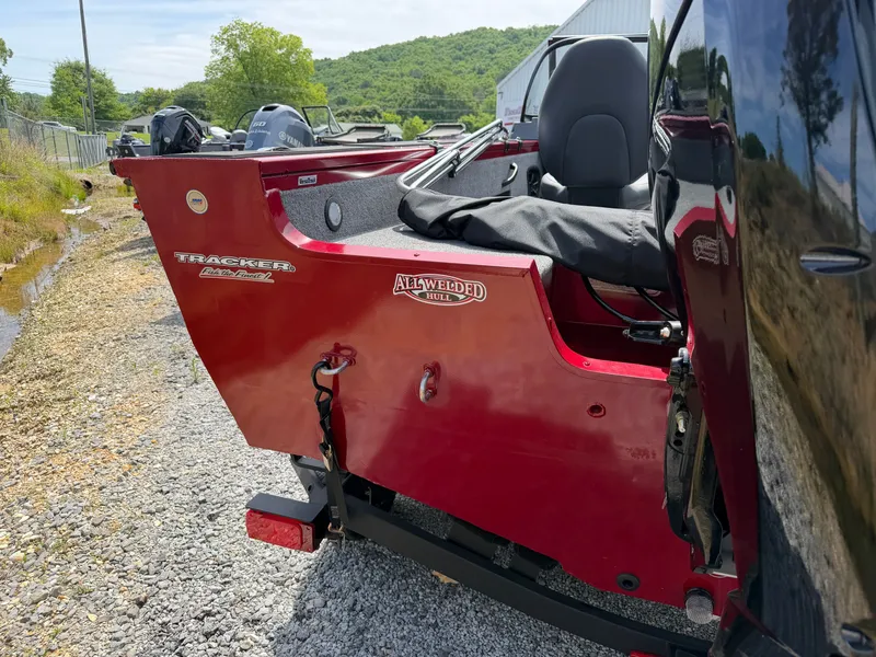 Slide: The Image of Red Tracker Targa 18 boat, 2025 model, parked on gravel path. - 19