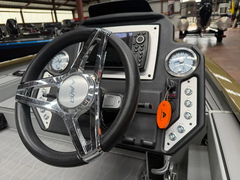 Slide: The Image of Avid 18XC 2024 boat dashboard with steering wheel and gauges. - 14