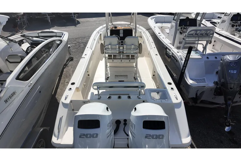 Slide: The Image of 2026 Bulls Bay 255 Center Console boat with dual Suzuki 200 engines, docked among other boats. - 11